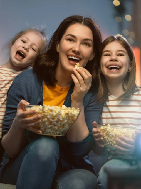 Family eating popcorn during movie night