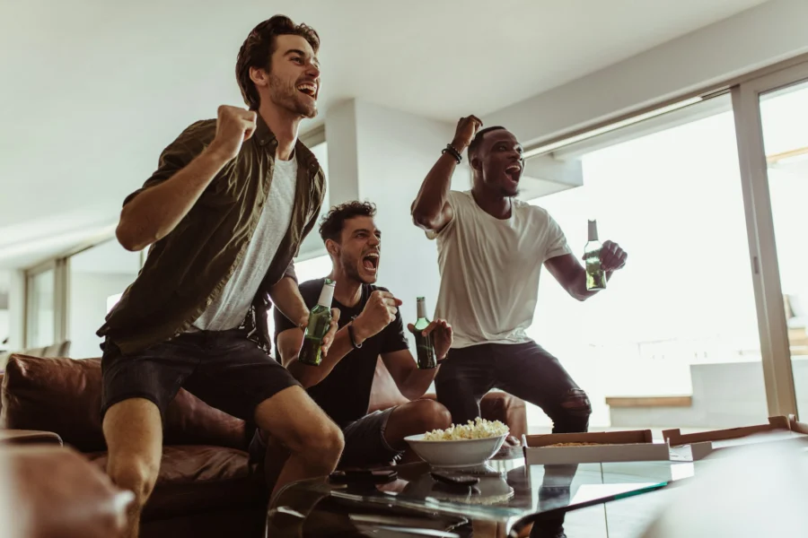 Friends cheering while watching a match at home