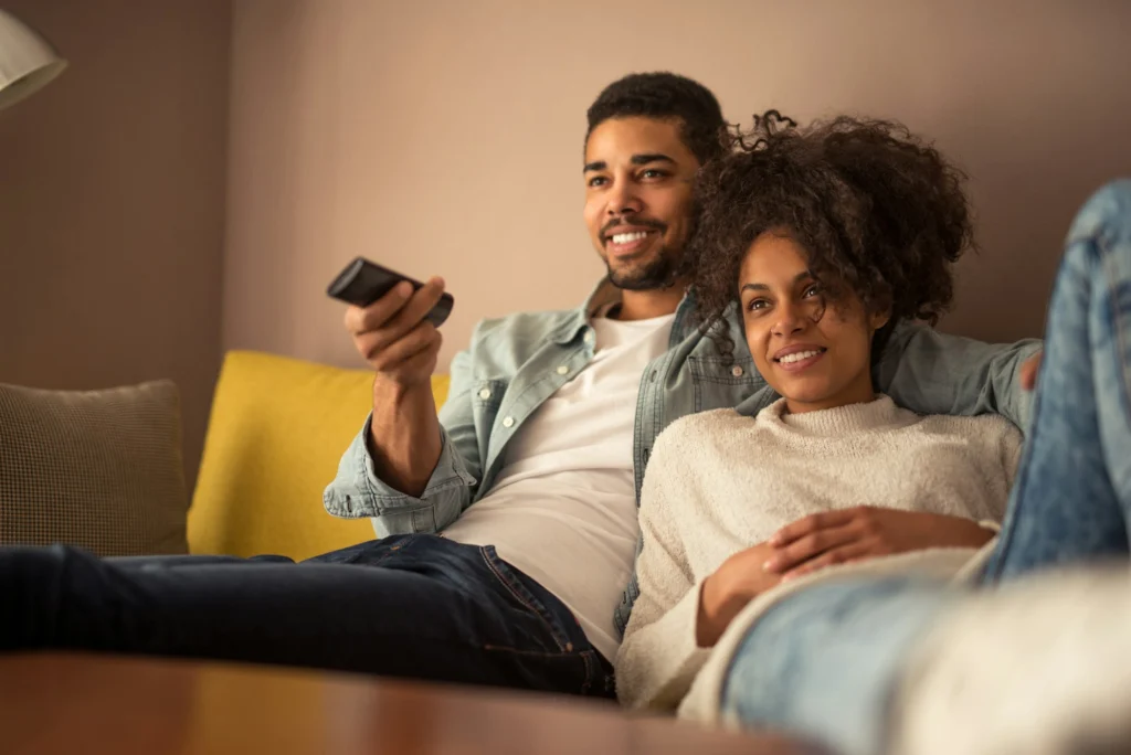 Couple relaxing on a sofa watching TV together