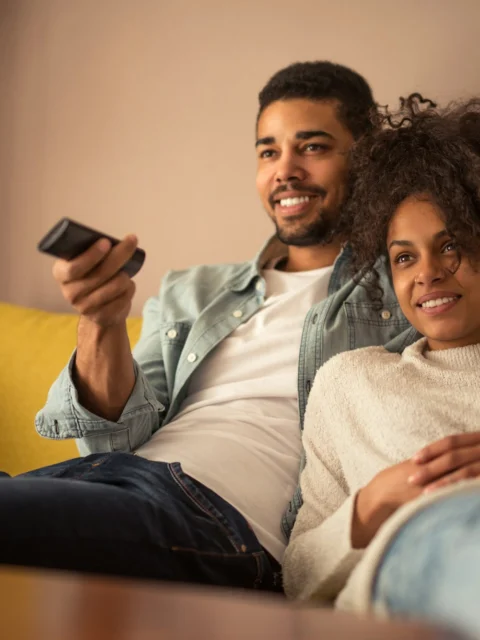 Couple relaxing on a sofa watching TV together