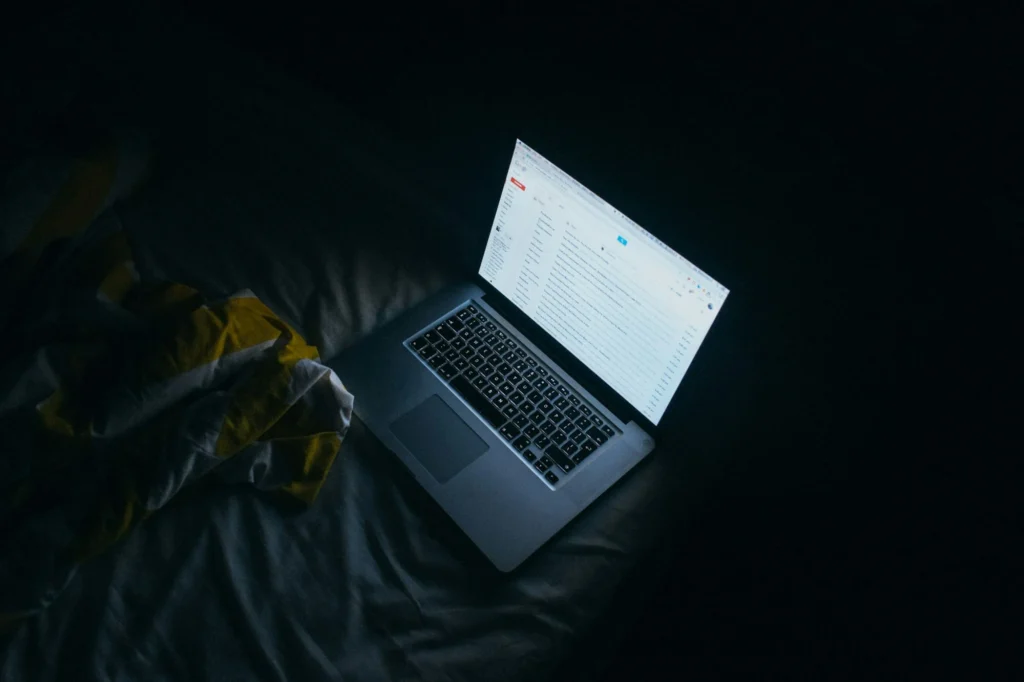 Laptop glowing in a dark room