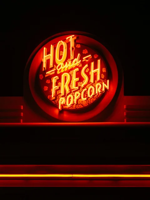 Neon popcorn sign glowing in the dark