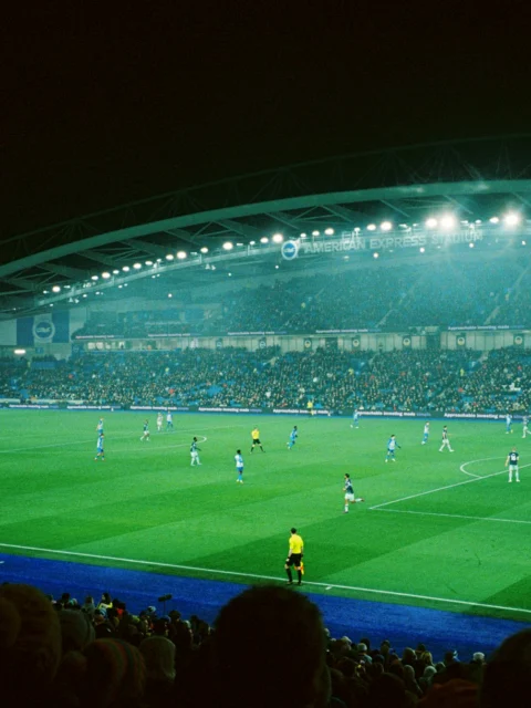 Football match in a floodlit stadium at night