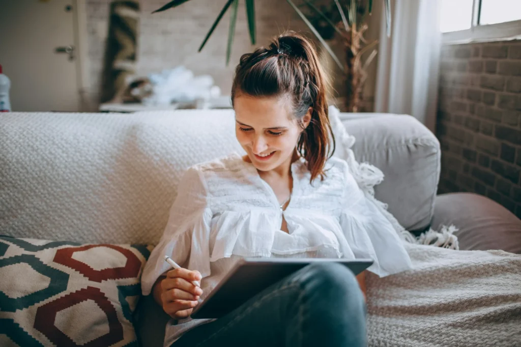 Woman relaxing on a sofa with a tablet